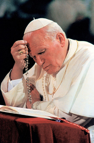 Pope John Paul II prays the rosary at Notre Dame du Chant d'Oiseau Church in Brussels, Belgium, in June 1995. Throughout his pontificate the Holy Father has shown a devotion to Mary. He has called the rosary his "favorite prayer." (CNS photo from Catholic Press Photo) (Aug. 27, 2003) See POPE25-MARY Aug. 28, 2003.